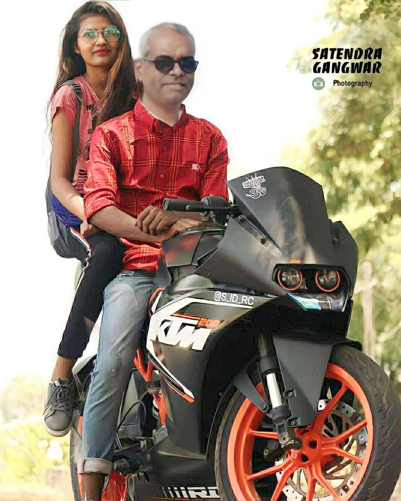 Two people riding an orange and black KTM motorcycle